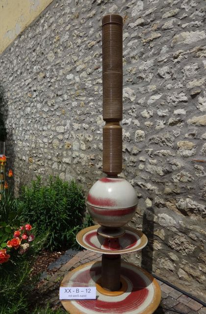 Moderner Gartenbrunnen aus winterfester Keramik mit gerillter Säule und Kugel rot-weiß