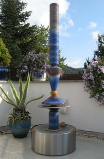 Designerbrunnen mit Edelstahl Behälter, gerillter Säule und Lichtreflexen über zwei farbige Kegel, dezente Akustik